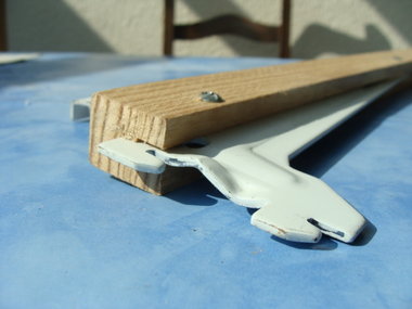 Détail de fixation de la console métallique dans le tasseau en bois